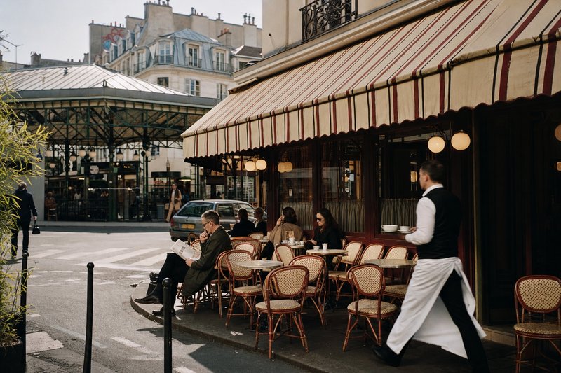 Corner terrace of Café Charlot on Rue de Bretagne in the Marais, Paris, with rattan chairs facing the street